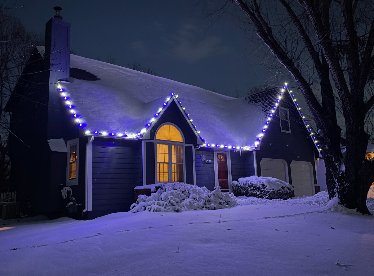 Christmas light installation on a snowy Cape Cod home in Lawrence, Kansas by First Response Exterior Lights