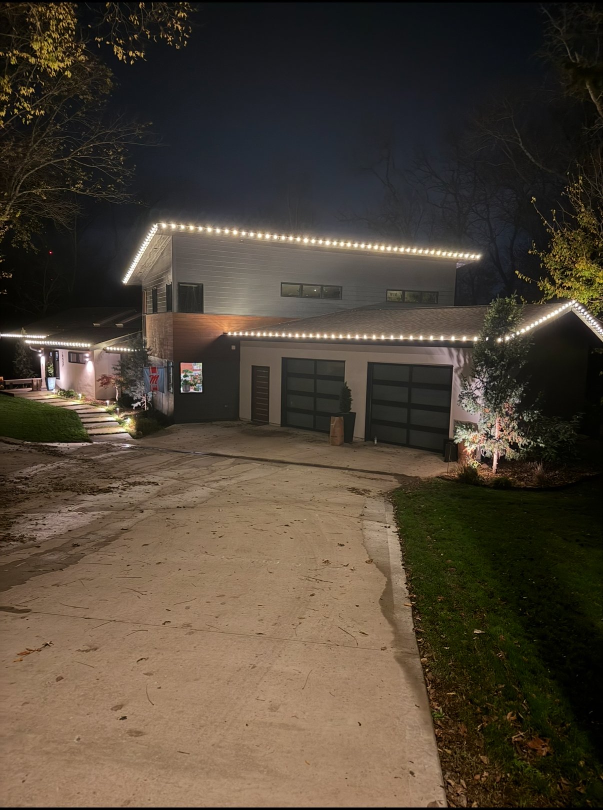 Christmas light installation on a warm white modern home in Lawrence, Kansas by First Response Exterior Lights