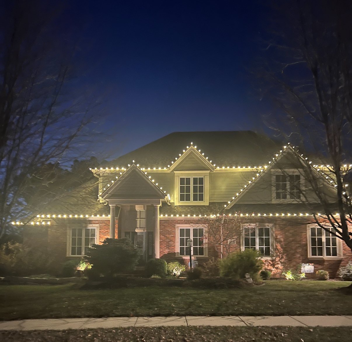 Warm white Christmas lights brick home